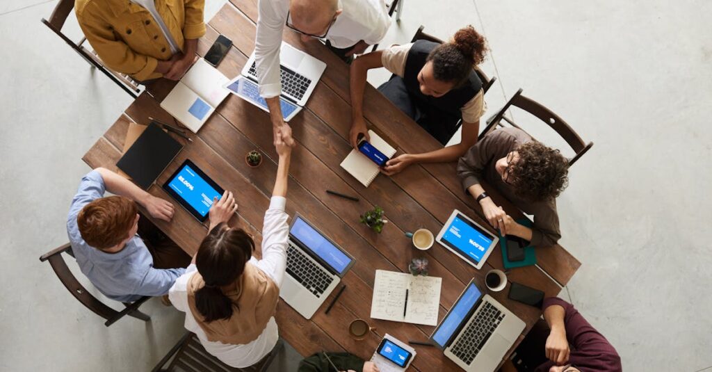Home Top view of a diverse team collaborating in an office setting with laptops and tablets, promoting cooperation.